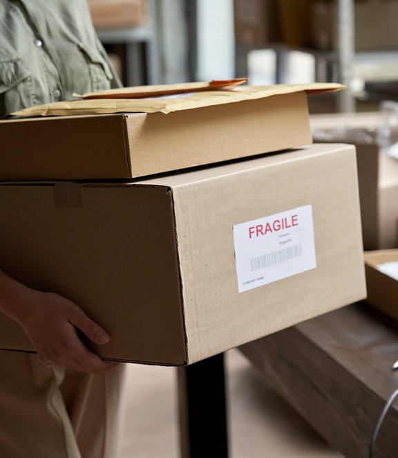 woman with 2 large parcels marked fragile