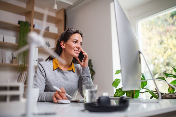 Businesswoman at desk with wind turbine