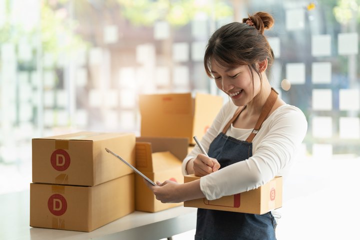 Asian lady signing parcel